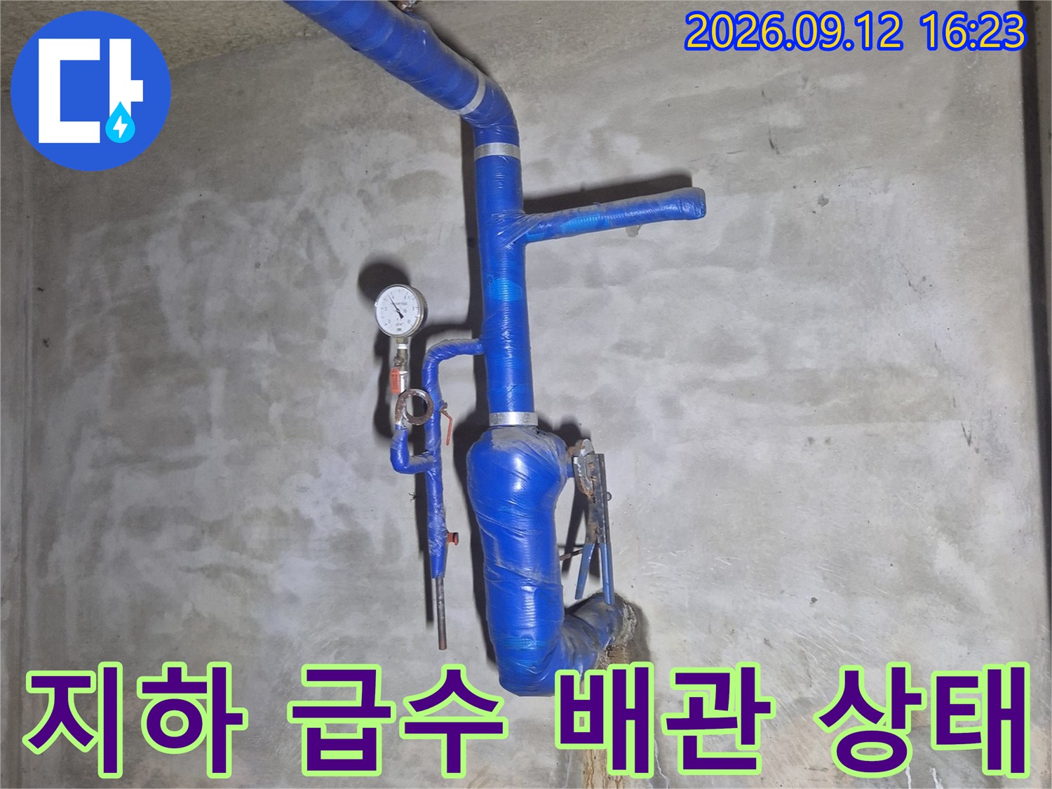 습기가 번진 콘크리트 벽과 파란색 보온재가 씌워진 배관 부근