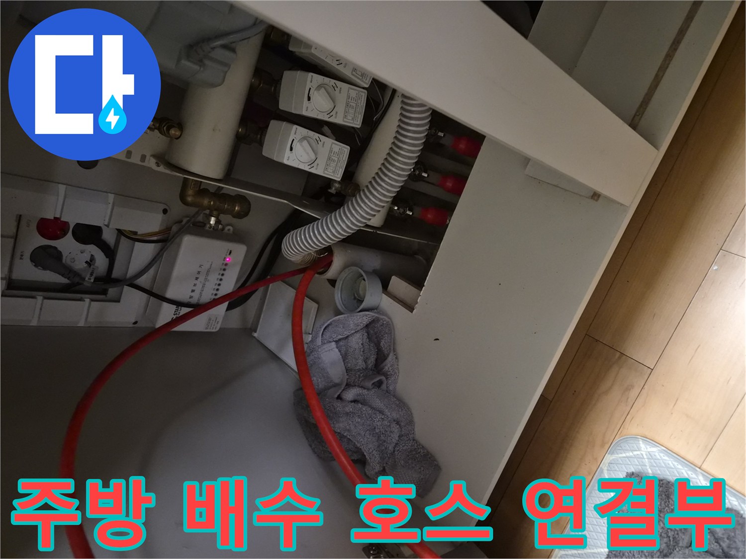 싱크대 아래쪽 배수 호스와 급수 밸브의 연결 상태를 촬영한 사진