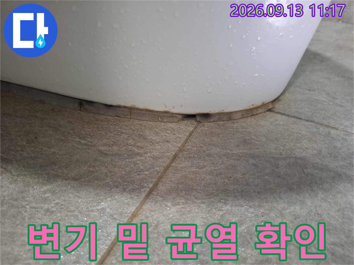 변기와 타일 사이의 벌어진 틈을 근접한 각도에서 찍은 사진입니다.