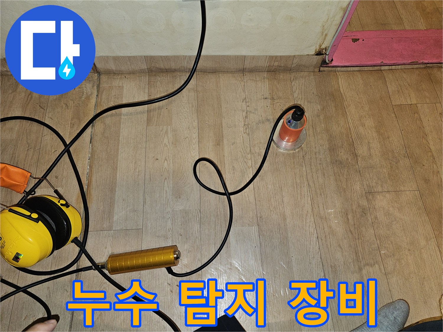 바닥에 놓인 노란색과 주황색의 누수 탐지기 세트