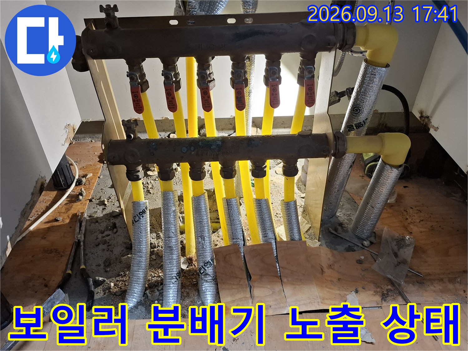 공사가 진행 중인 보일러 분배기의 노란색 배관과 은색 보온재 배관 모습입니다.