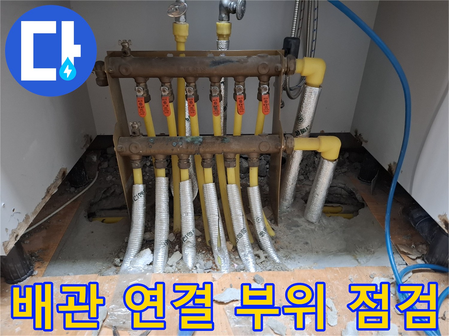 노란색 난방 배관과 은색 보온재로 감싸진 연결 부위의 상세 모습