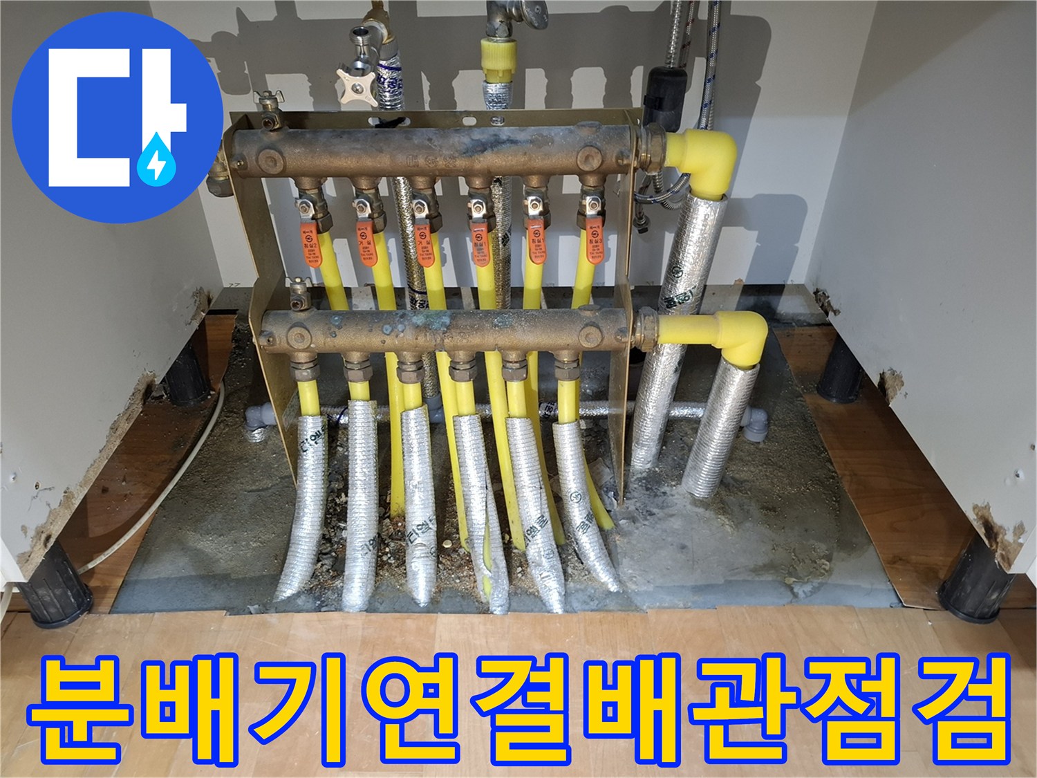 분배기 밸브와 노란색 난방 배관이 연결된 현장 사진입니다.