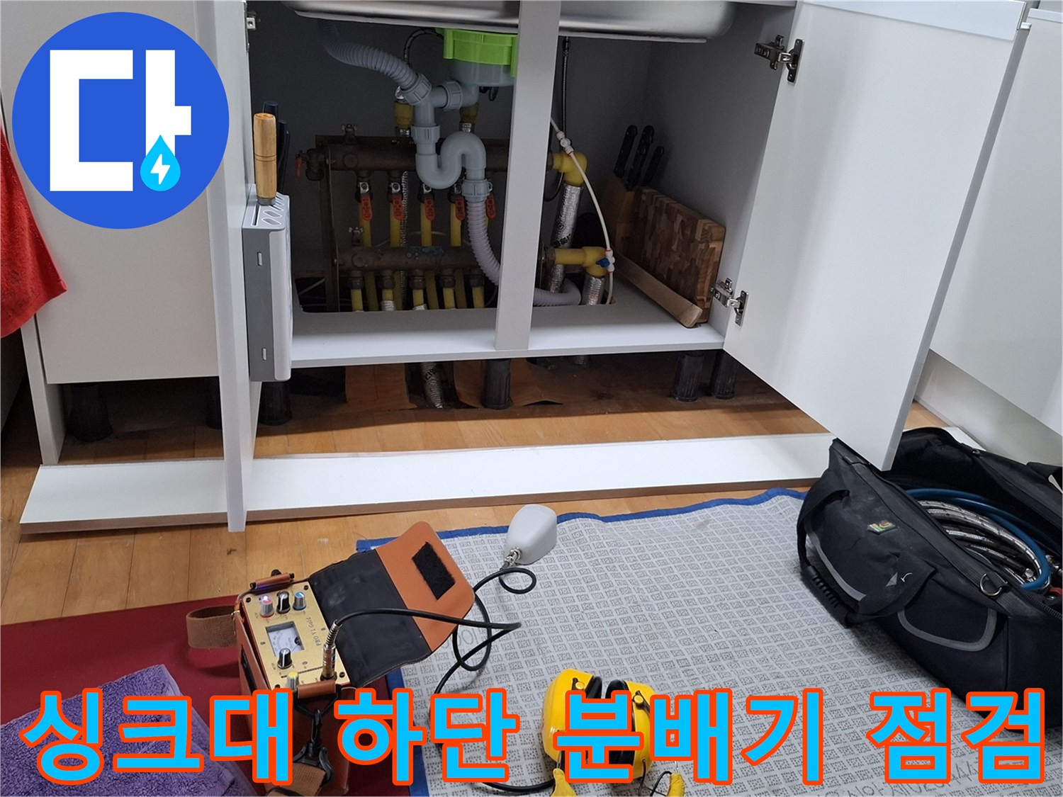 싱크대 내부의 난방 분배기와 검사 도구가 준비된 모습입니다