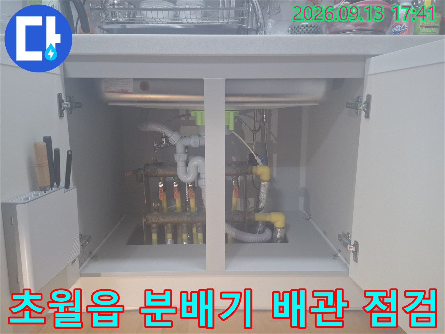 싱크대 하단장 내부-보일러 분배기와 연결된 노란색 배관