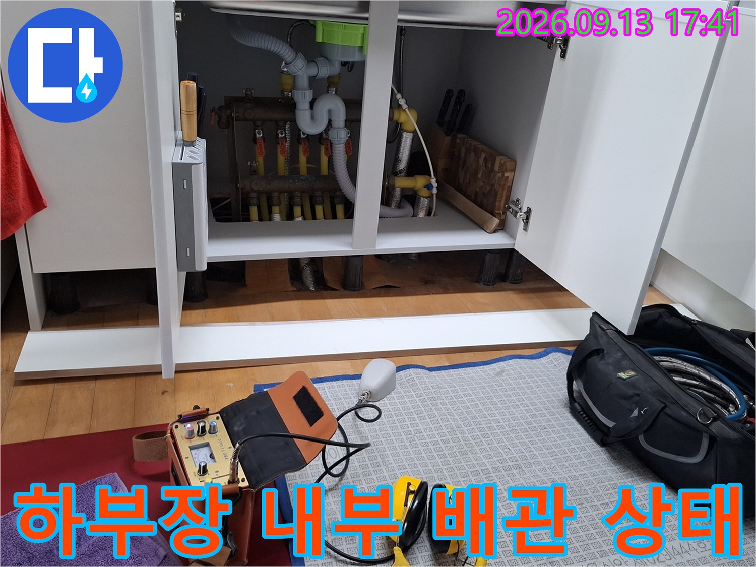 싱크대 하부장에 노출된 분배기와 여러 가지 연결 배관들입니다.