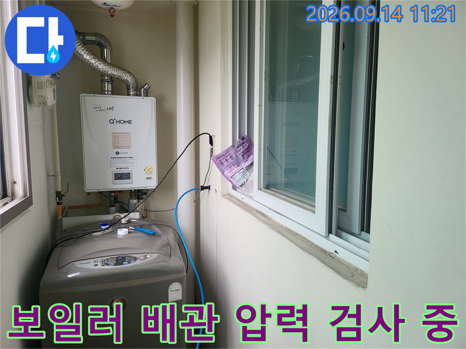 보일러 하단 배관에 연결된 파란색 호스와 압력 측정 장비