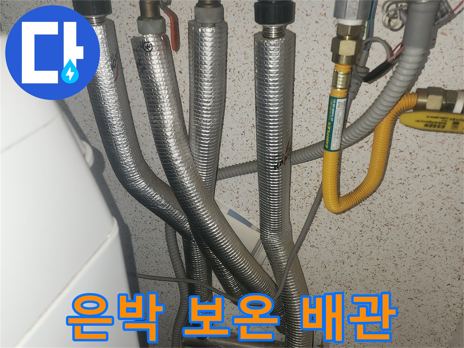 은박 보온재로 감싸진 여러 개의 보일러 배관들입니다.