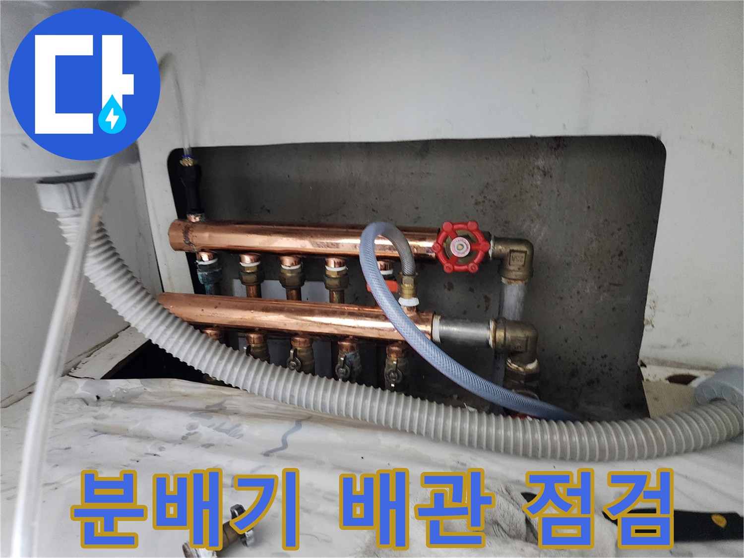 구리 재질의 난방 분배기와 연결된 호스 및 압력 측정 장치