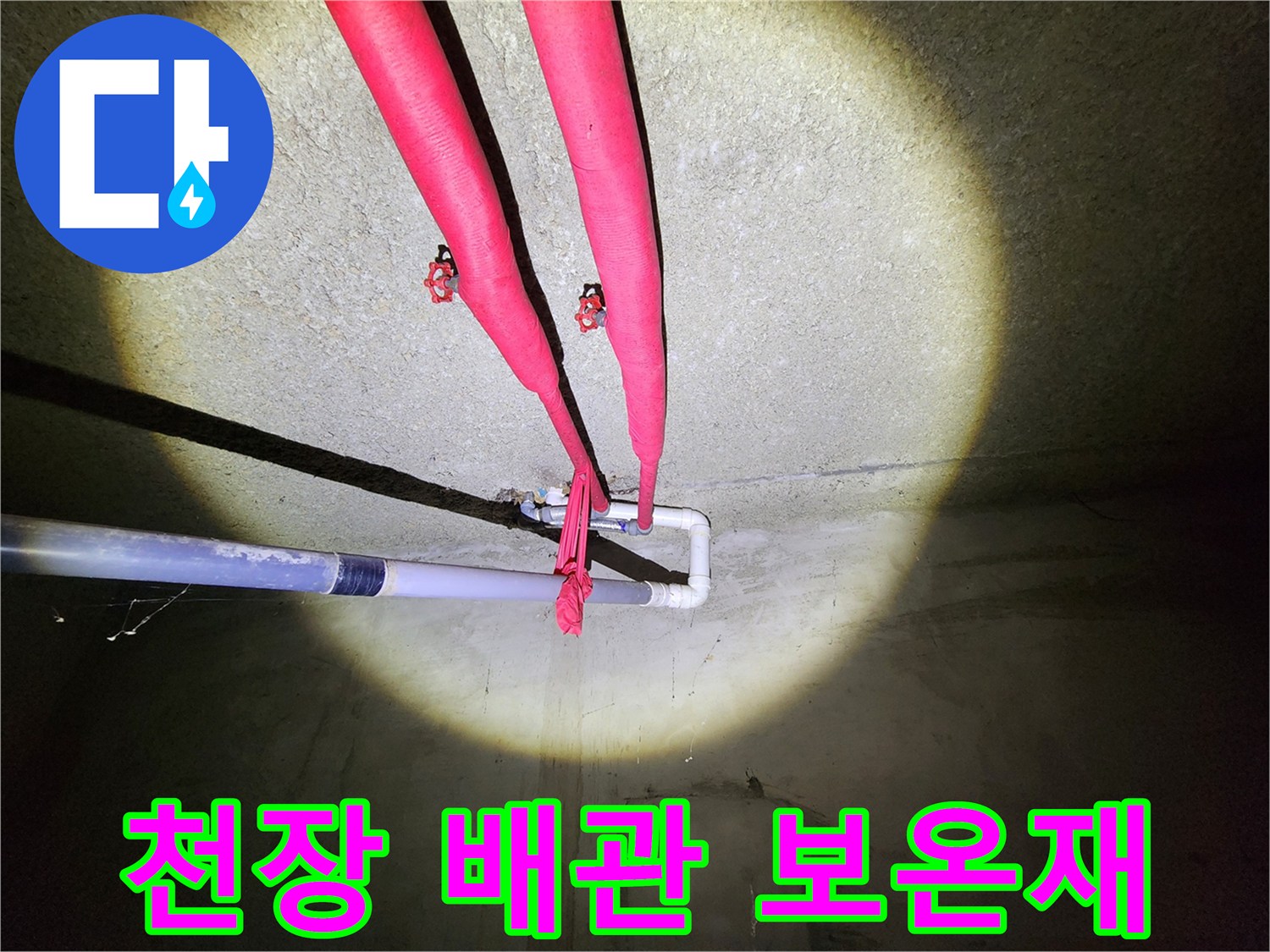 붉은색 보온재로 감싸져 있는 천장 매립형 배관의 모습