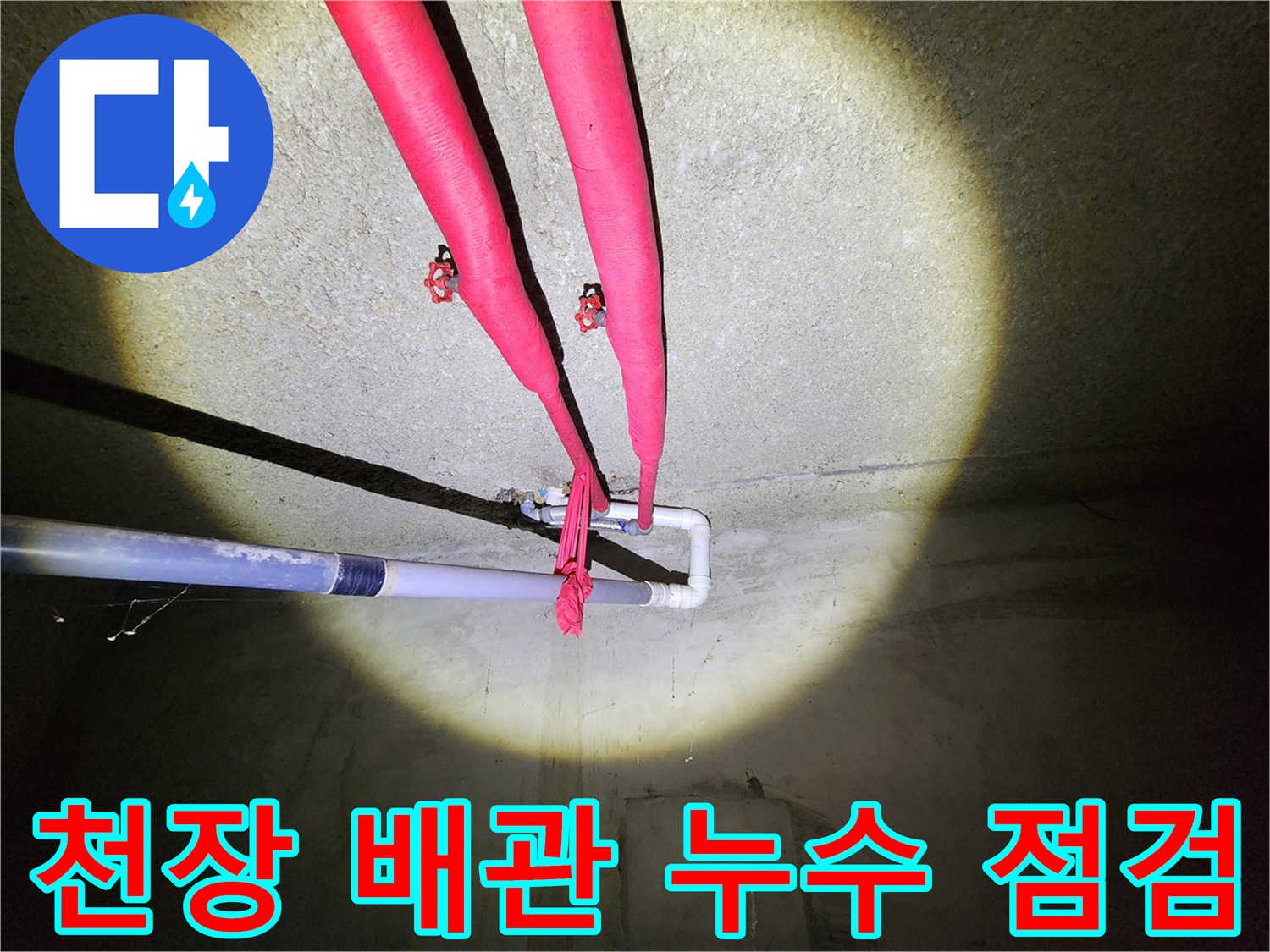 붉은색 보온재로 덮인 지하 천장 배관의 모습
