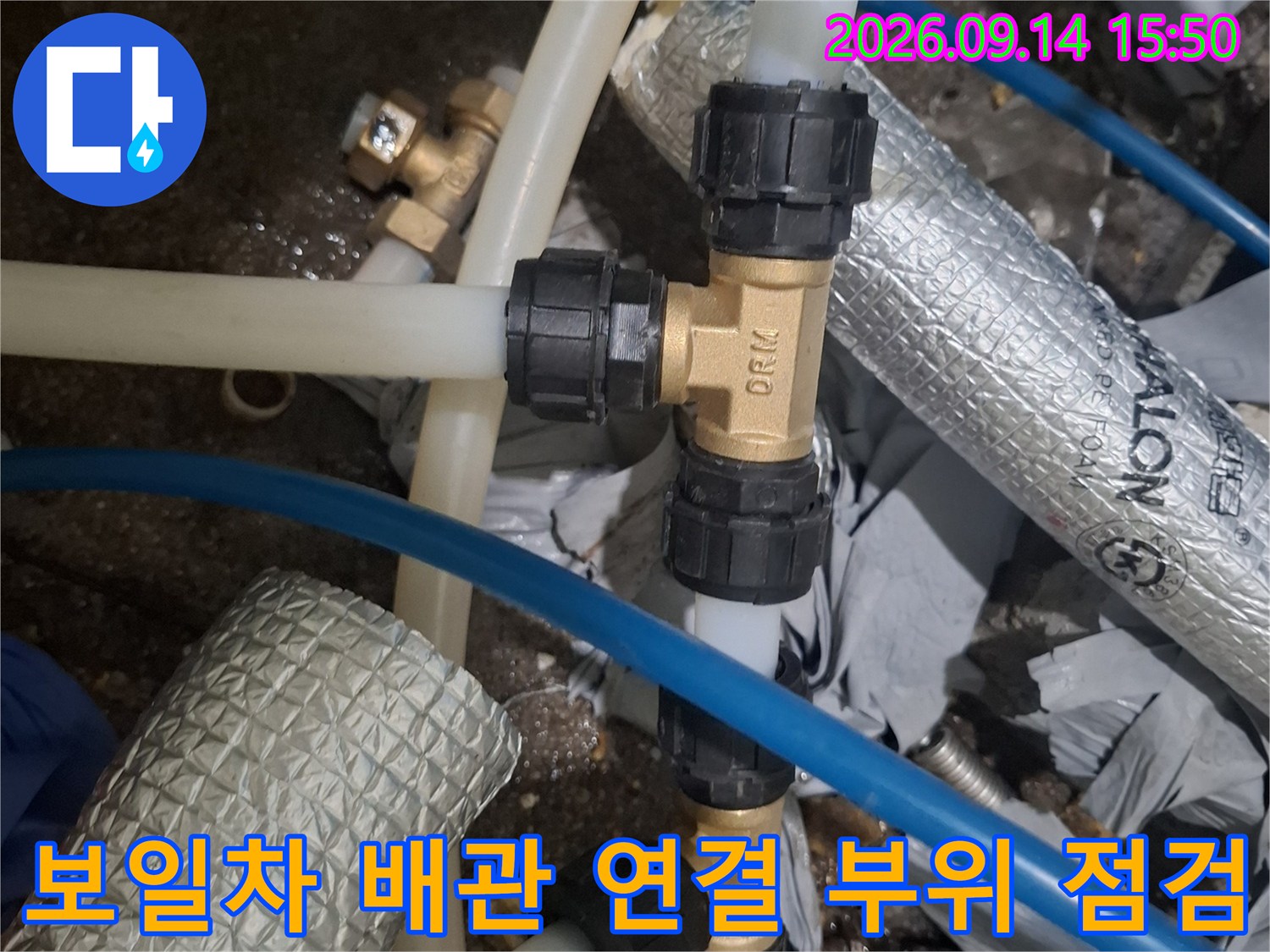 보일러실 내 배관의 투명 호스와 검은색 연결 부품 사진