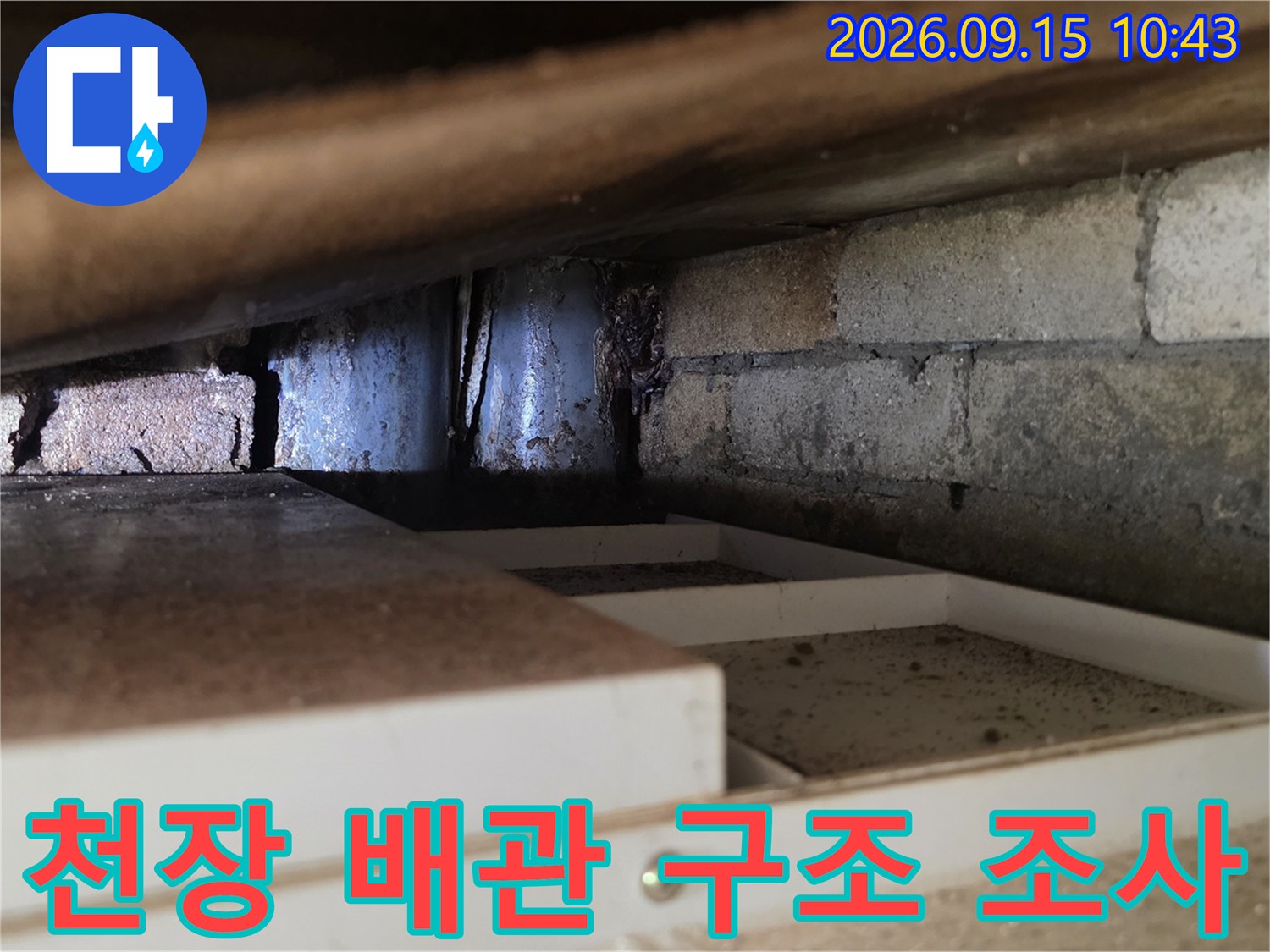 천장 안쪽의 노출된 배관과 벽돌 구조물의 상태