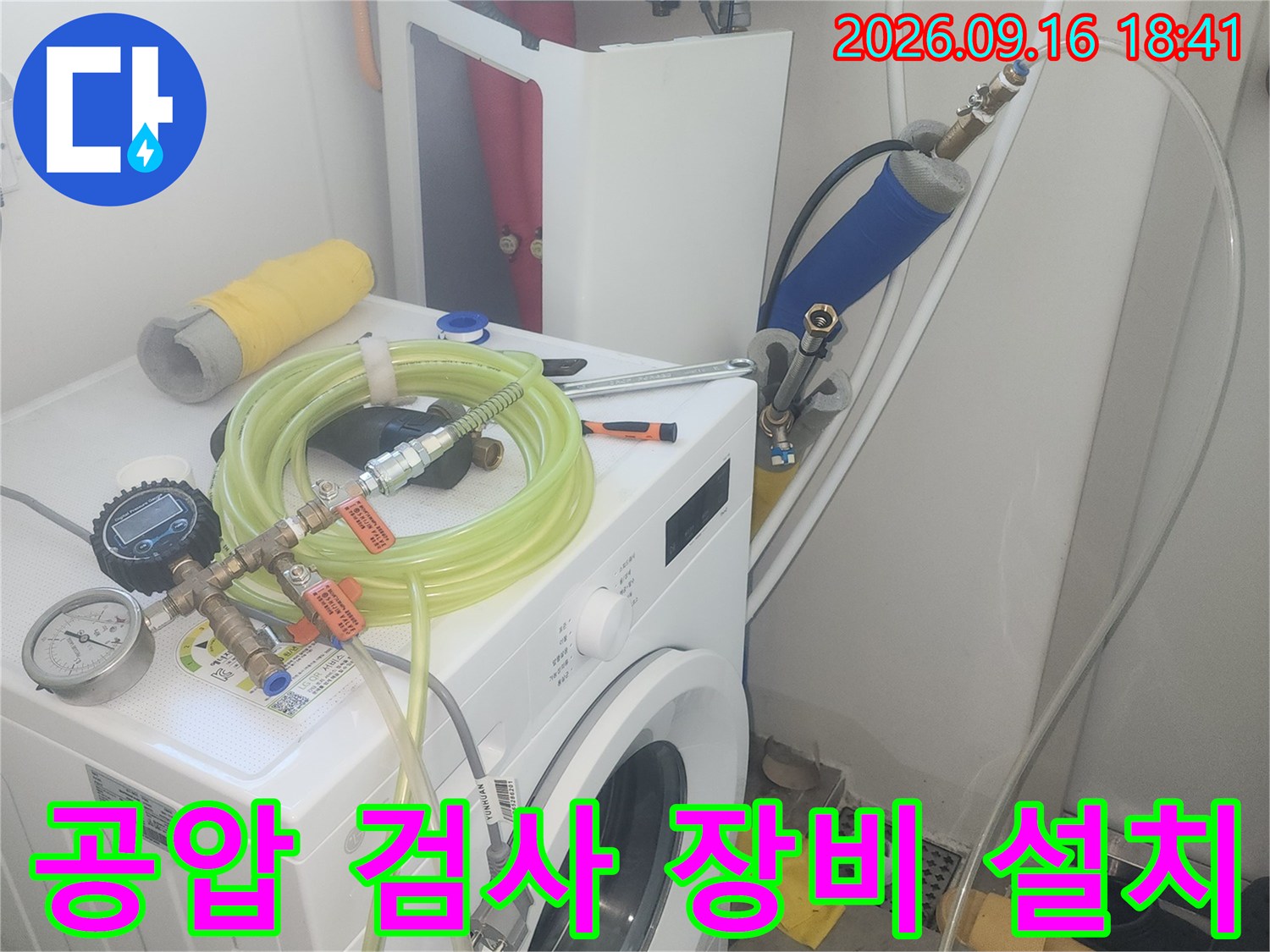 수도 밸브에 연결된 압력 측정용 호스와 게이지 모습입니다.