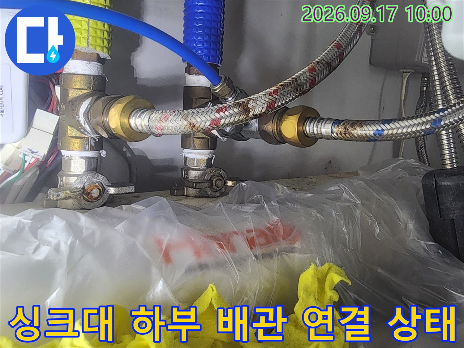 싱크대 아래쪽 수도 밸브와 금속 호스의 연결 부위 상세 사진