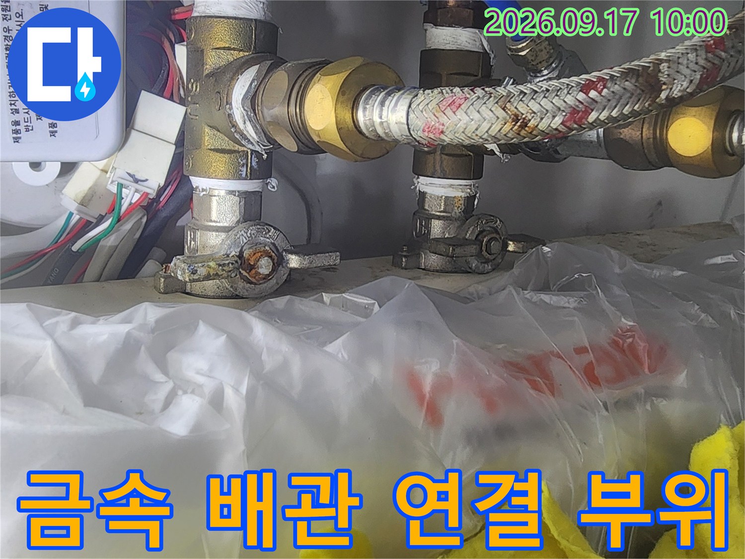 싱크대 하단 금속 배관과 수전 연결 부품 상세 모습