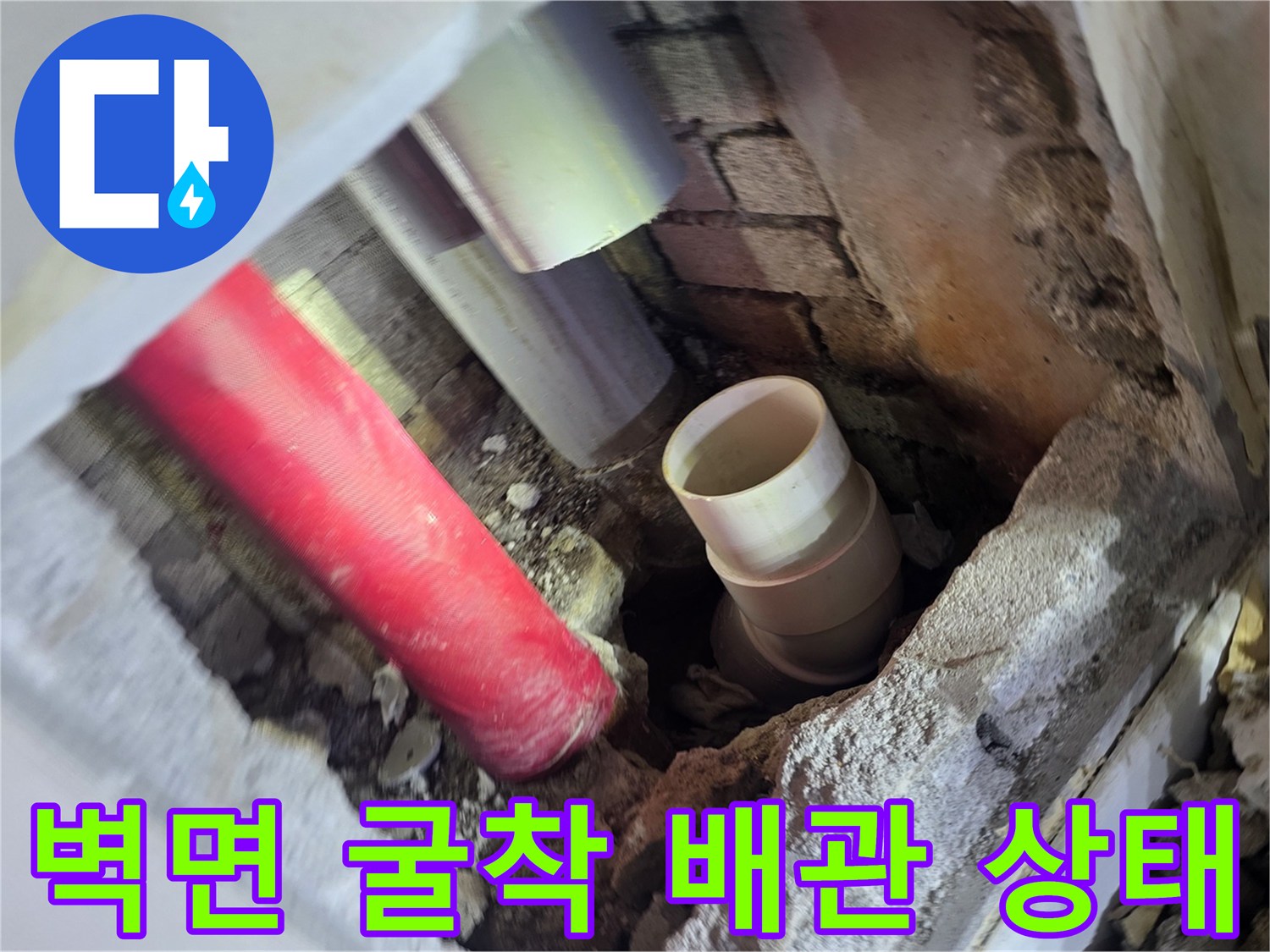 아파트 벽면 내부의 붉은색 및 회색 배관 노출 상태