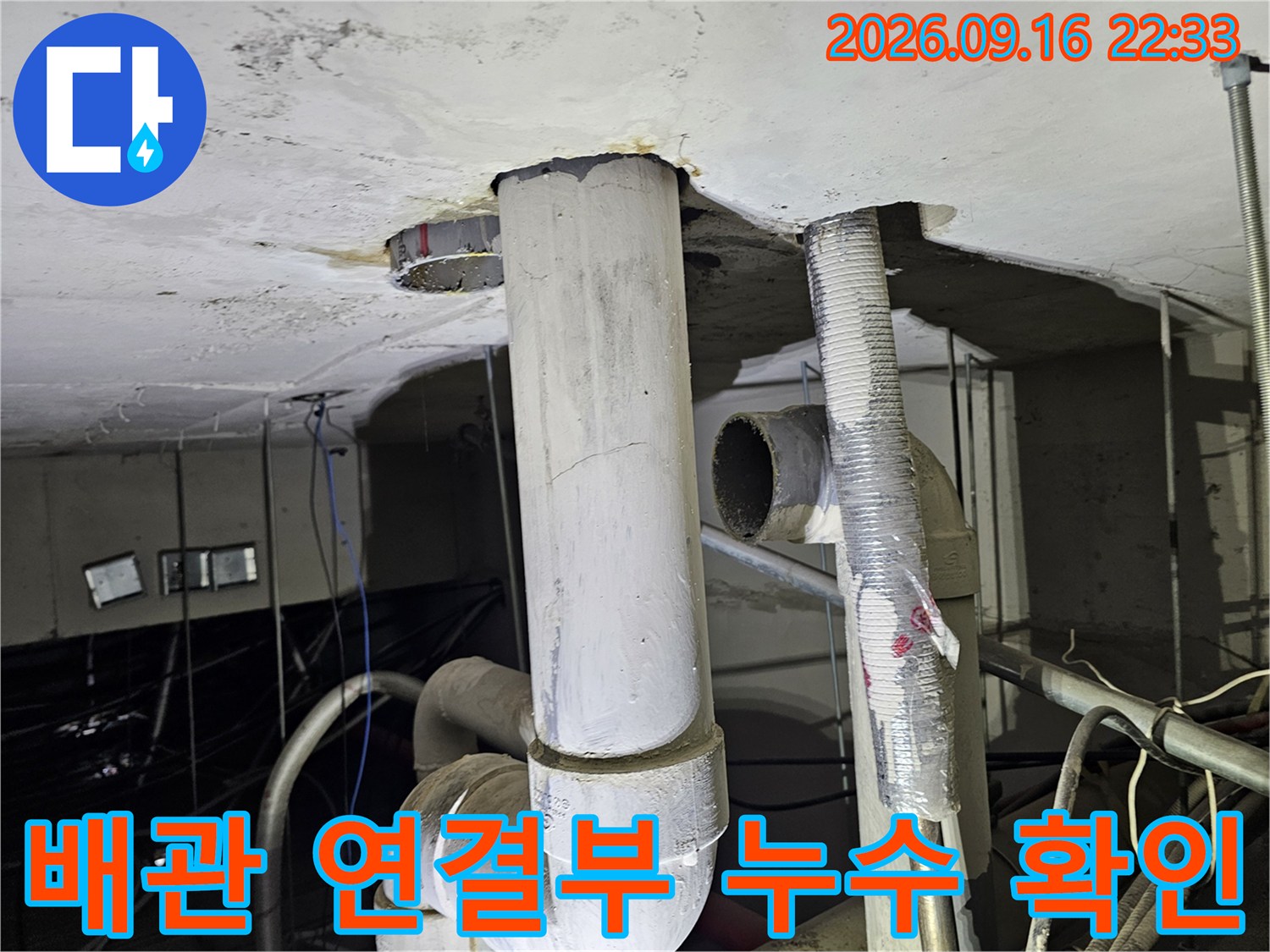 천장 내부로 노출된 굵은 배관과 연결 부위의 상태를 나타냅니다.
