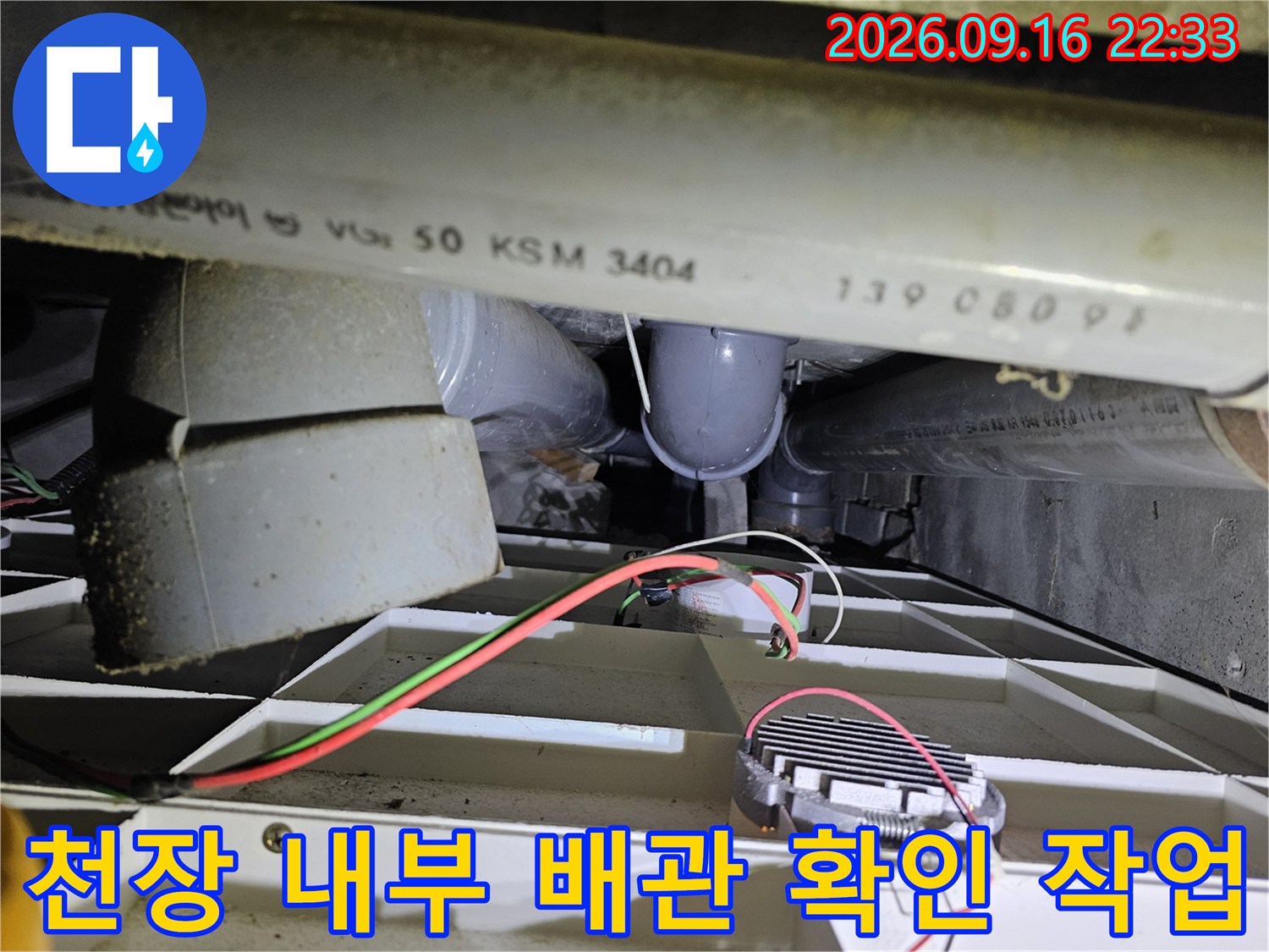 천장 점검구 안쪽의 배관과 전선 연결 부위 근접 촬영입니다.