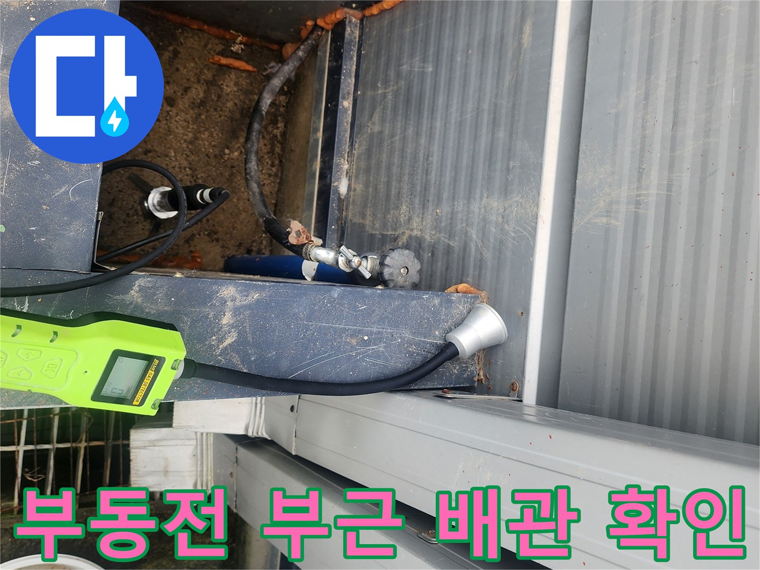 파란색 장비와 연결된-외부 수도 배관의 이상 유무 확인 작업